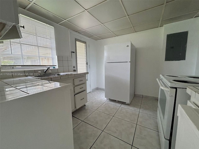 kitchen with electric panel, a drop ceiling, white cabinets, and white appliances