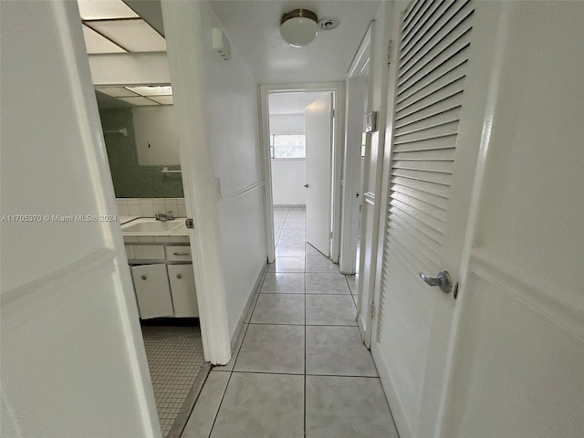 corridor with light tile patterned flooring and sink