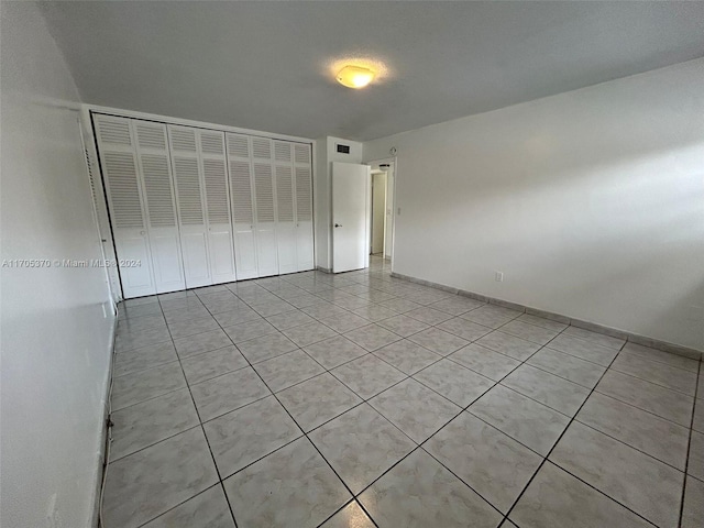 unfurnished bedroom with a closet and light tile patterned flooring