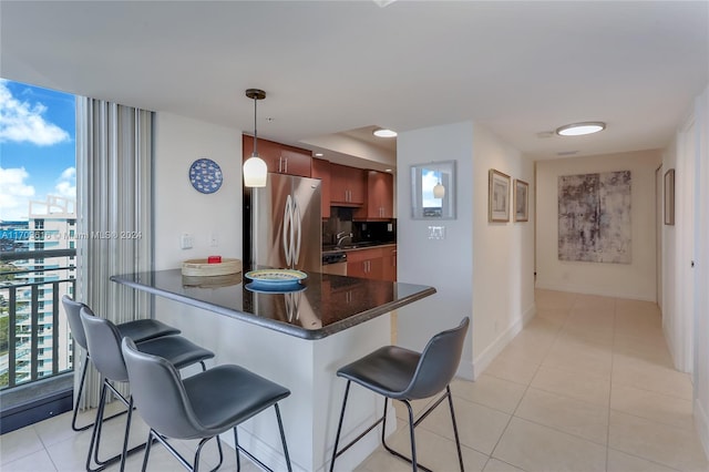 kitchen with tasteful backsplash, kitchen peninsula, decorative light fixtures, a breakfast bar, and appliances with stainless steel finishes