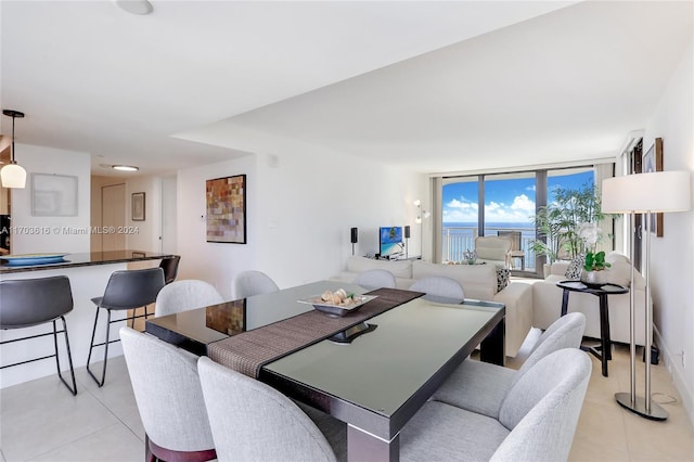 dining space featuring light tile patterned flooring and a wall of windows