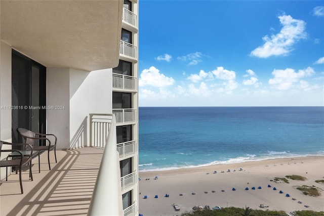 balcony with a water view and a beach view