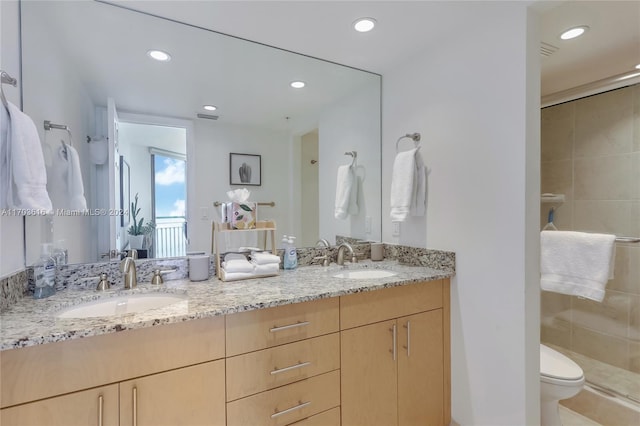 bathroom with a shower with door, vanity, and toilet