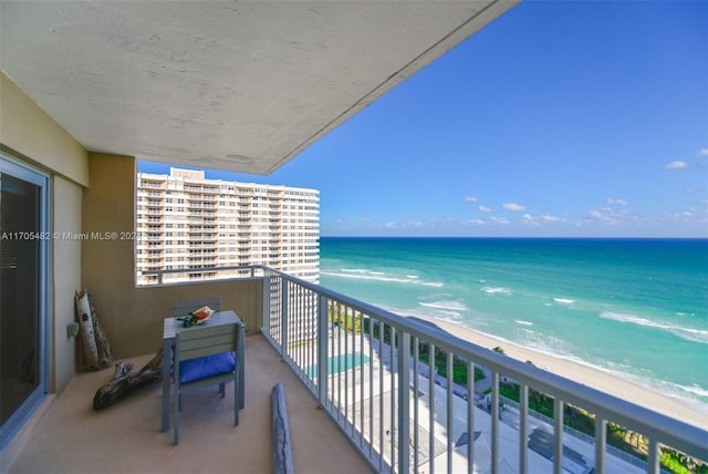 balcony with a water view and a view of the beach