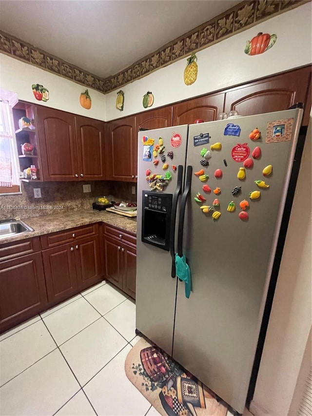 kitchen with sink, light tile patterned floors, and stainless steel refrigerator with ice dispenser