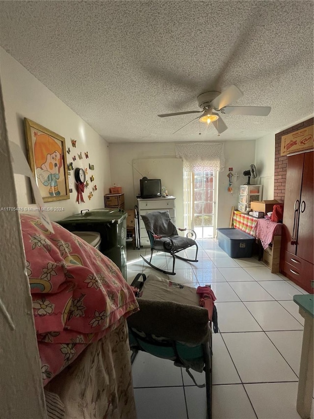 bedroom featuring a textured ceiling, ceiling fan, and light tile patterned flooring