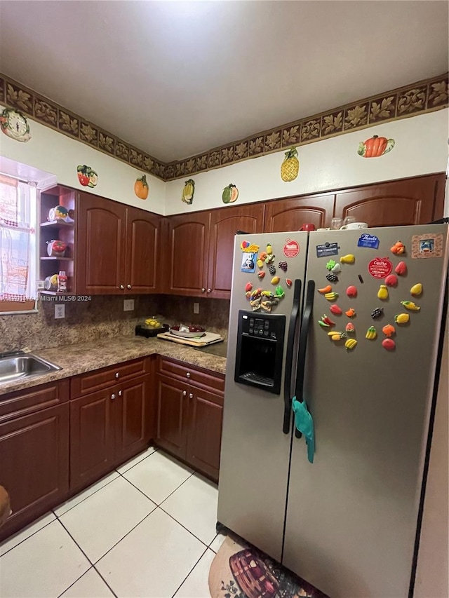 kitchen with sink, light tile patterned floors, stainless steel refrigerator with ice dispenser, and tasteful backsplash