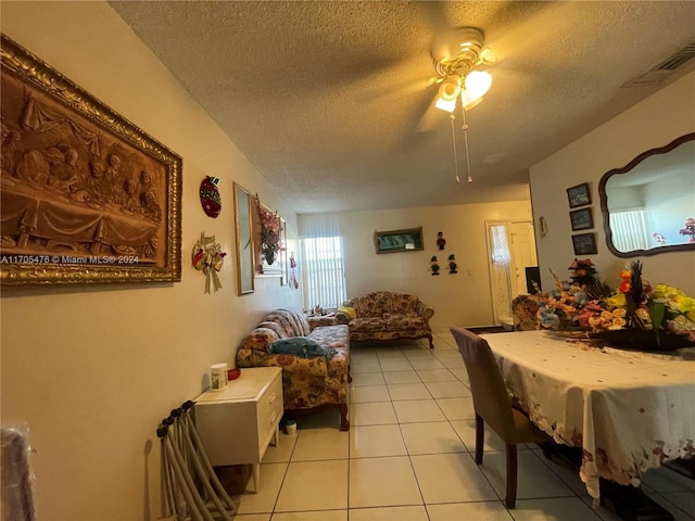 dining area featuring ceiling fan, light tile patterned floors, and a textured ceiling