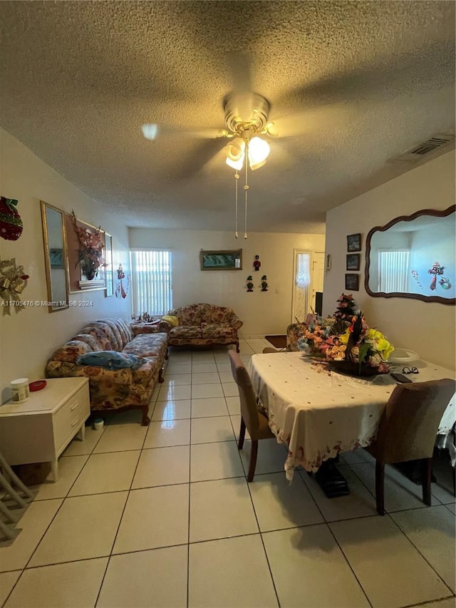 dining room with ceiling fan, light tile patterned floors, and a textured ceiling