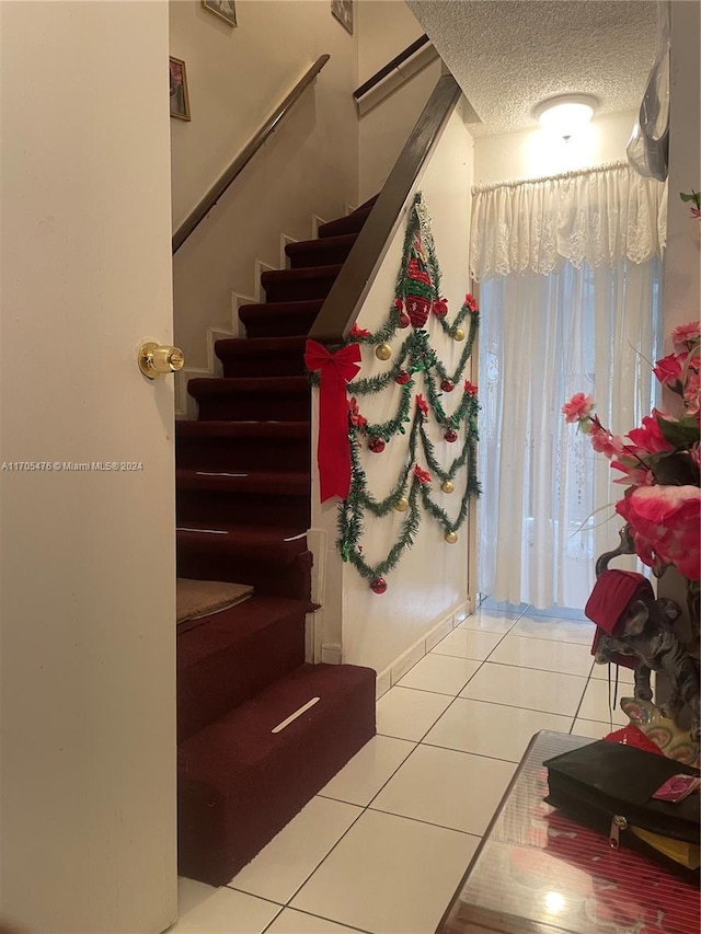 stairs featuring a textured ceiling and tile patterned floors