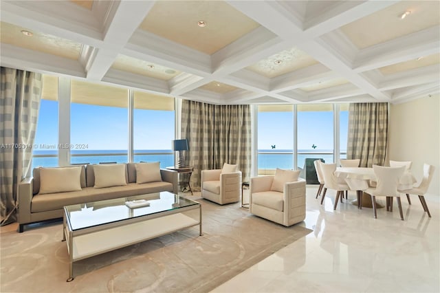 living room with beam ceiling, a water view, a healthy amount of sunlight, and a wall of windows