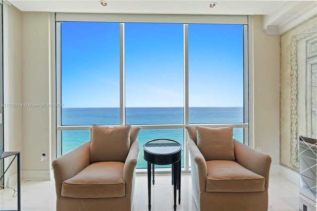 living area featuring a water view and a wall of windows