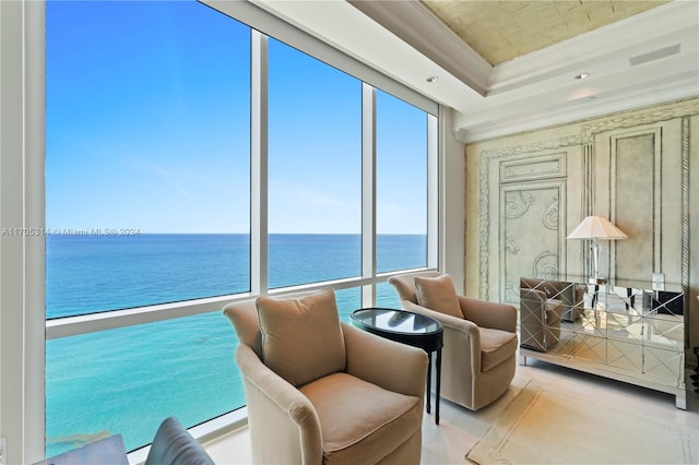 sunroom / solarium featuring a water view and a tray ceiling