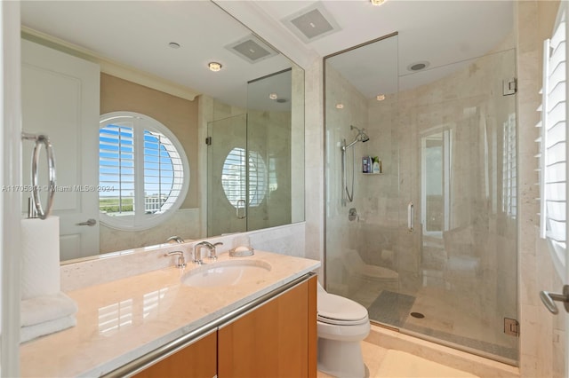 bathroom featuring vanity, toilet, and a shower with shower door