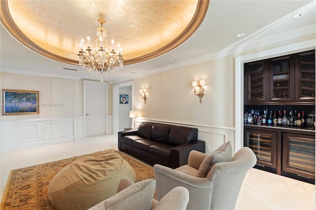 living room with a raised ceiling, ornamental molding, bar, and a chandelier