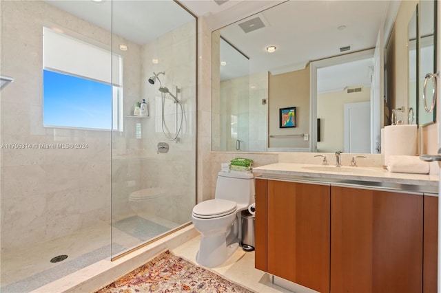 bathroom featuring toilet, a tile shower, and vanity