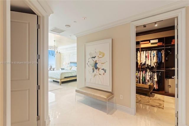 corridor featuring crown molding and a notable chandelier