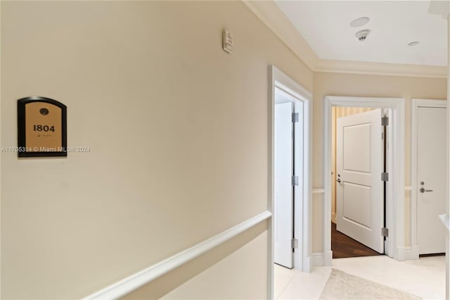 corridor with crown molding and light tile patterned flooring