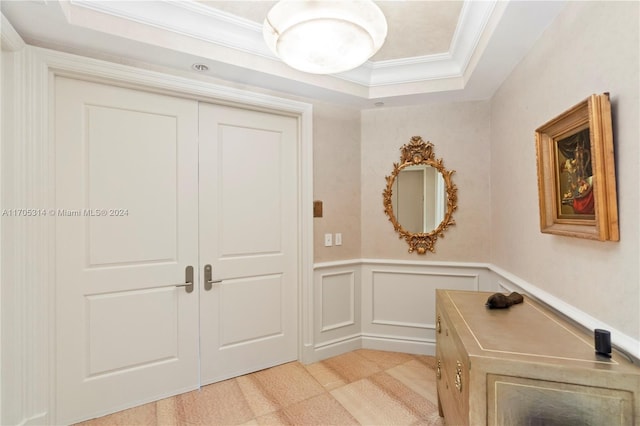 interior space with a raised ceiling and crown molding