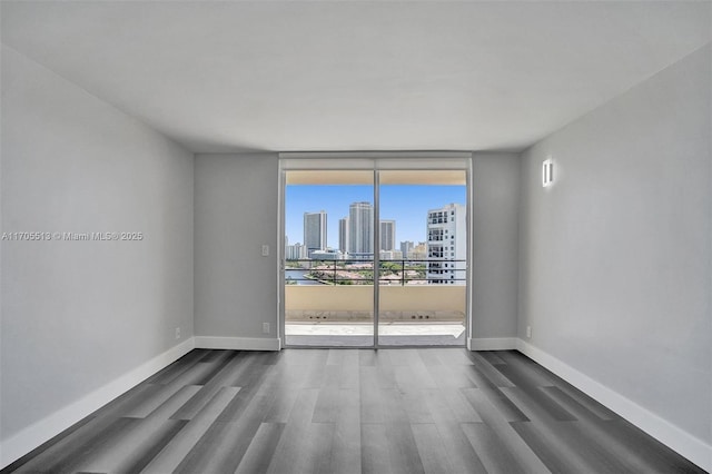 spare room featuring dark hardwood / wood-style floors and a wall of windows