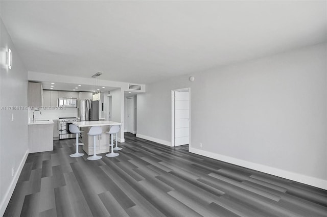 unfurnished living room with sink and dark hardwood / wood-style floors