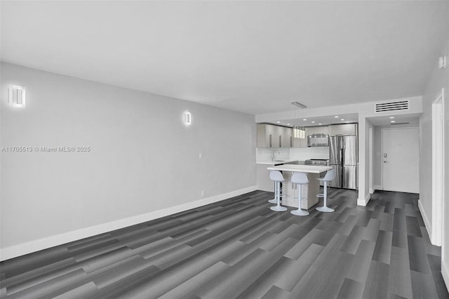 unfurnished living room with dark hardwood / wood-style flooring and sink