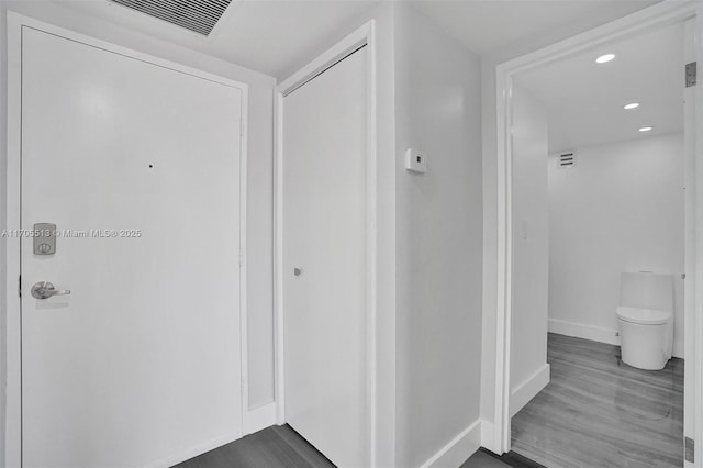 interior space with hardwood / wood-style flooring and toilet