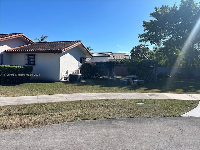 view of side of home with a lawn and central AC unit