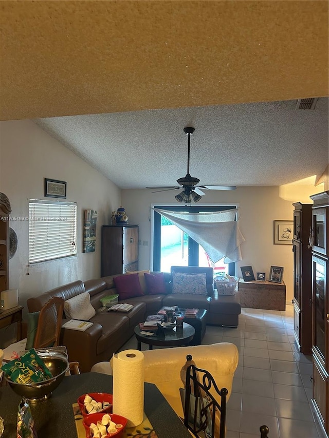 tiled living room featuring a textured ceiling, vaulted ceiling, and ceiling fan