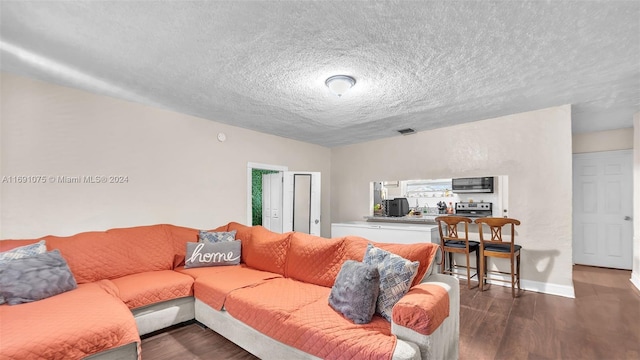 living room with a textured ceiling and dark wood-type flooring