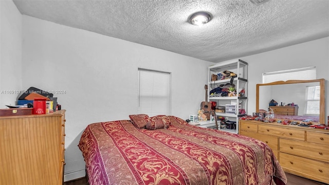 bedroom featuring wood-type flooring and a textured ceiling