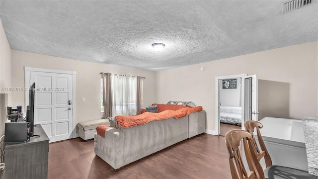 living room with a textured ceiling and dark wood-type flooring