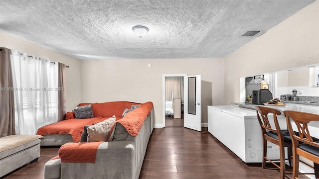 living room featuring a textured ceiling and dark hardwood / wood-style floors