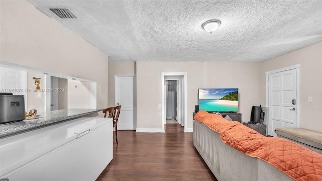 living room with dark hardwood / wood-style floors and a textured ceiling