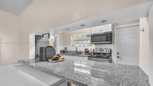 kitchen featuring kitchen peninsula, stainless steel appliances, white cabinetry, and sink