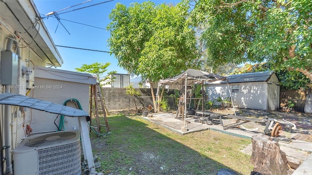 view of yard with central AC, a storage unit, and a patio area