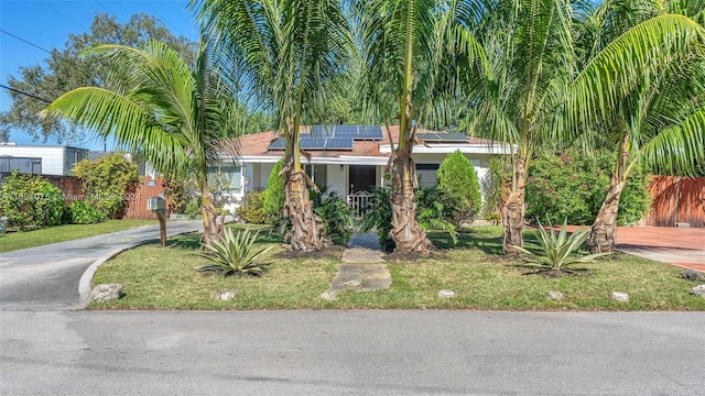 view of front of home with solar panels, a porch, and a front lawn