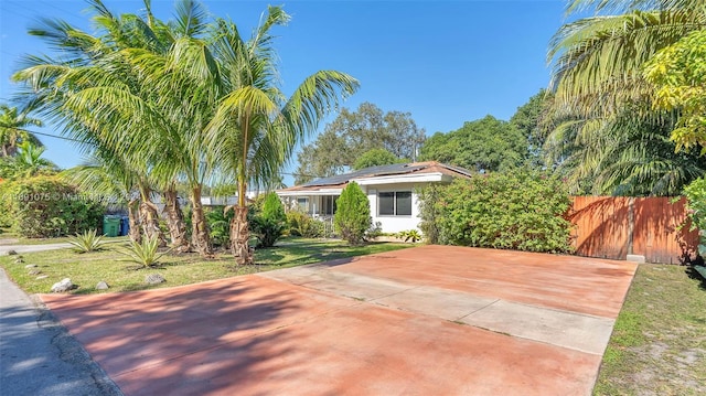 view of front of house with a front yard and solar panels