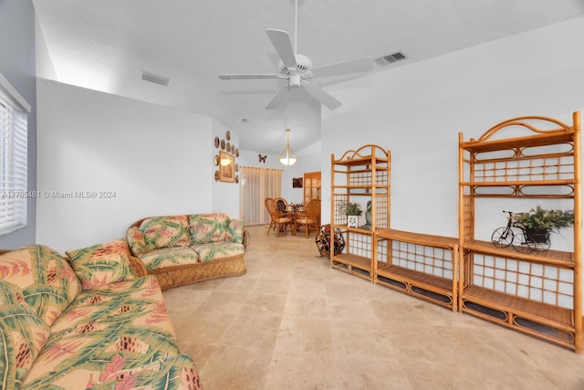 living room featuring ceiling fan and a textured ceiling