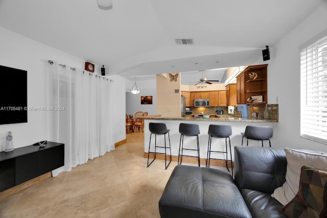 kitchen featuring kitchen peninsula, appliances with stainless steel finishes, tasteful backsplash, and a healthy amount of sunlight