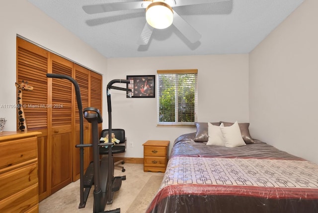 carpeted bedroom with a textured ceiling, a closet, and ceiling fan