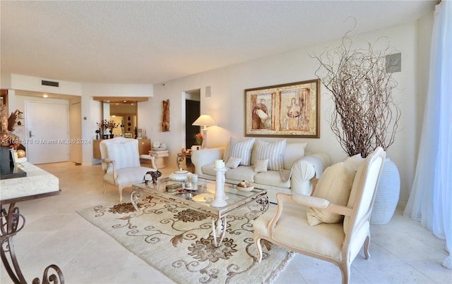 living room featuring light tile patterned floors and a textured ceiling