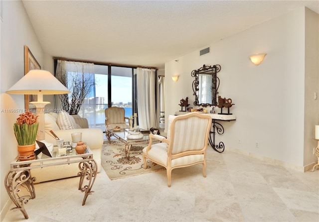 living room featuring a textured ceiling and a water view