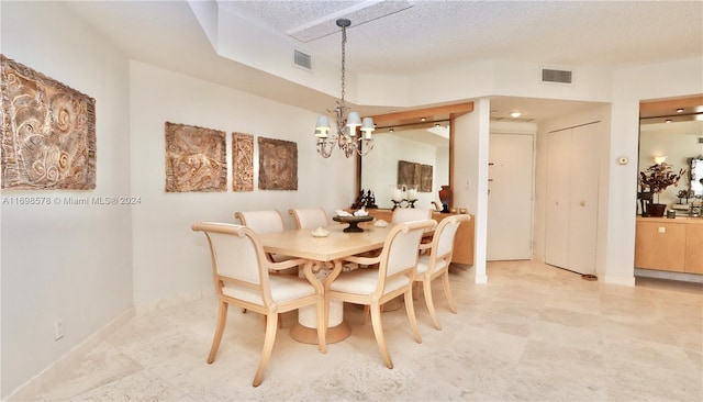 dining space featuring a textured ceiling and an inviting chandelier