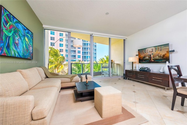 tiled living room featuring a textured ceiling and expansive windows