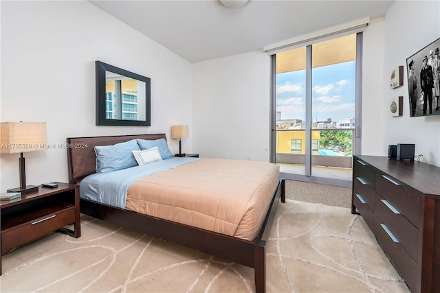 bedroom with access to exterior and light colored carpet