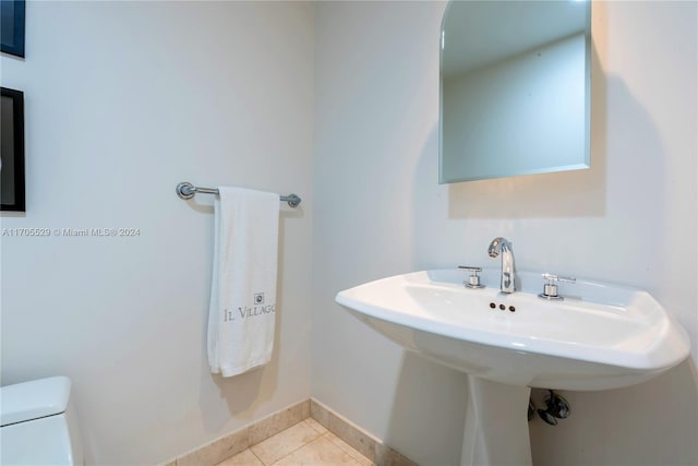 bathroom featuring toilet, tile patterned floors, and sink