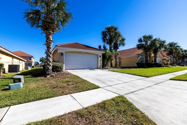 view of front of home featuring cooling unit, a front yard, and a garage