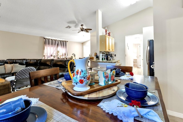 dining space with a textured ceiling, ceiling fan, and lofted ceiling