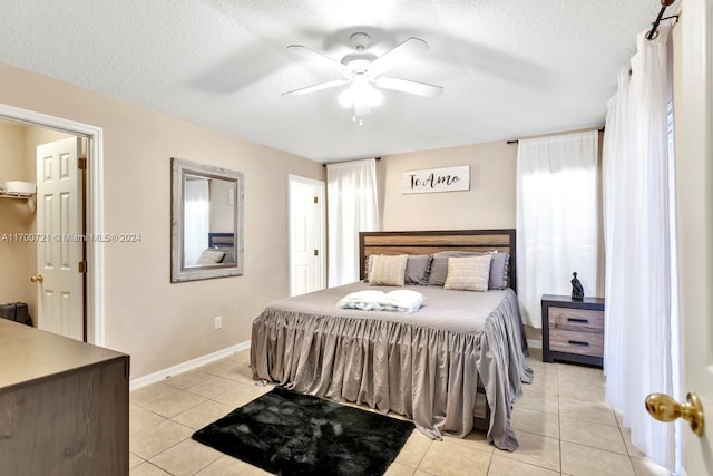 tiled bedroom featuring ceiling fan and a textured ceiling